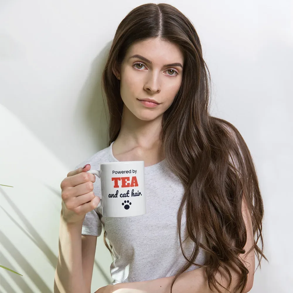 Powered by tea and cat hair — 11oz mug: In hand (lifestyle)